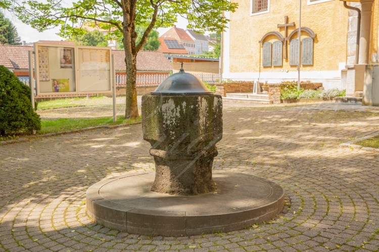 Taufstein mit Deckel am Kirchplatz in Markt Hartmannsdorf